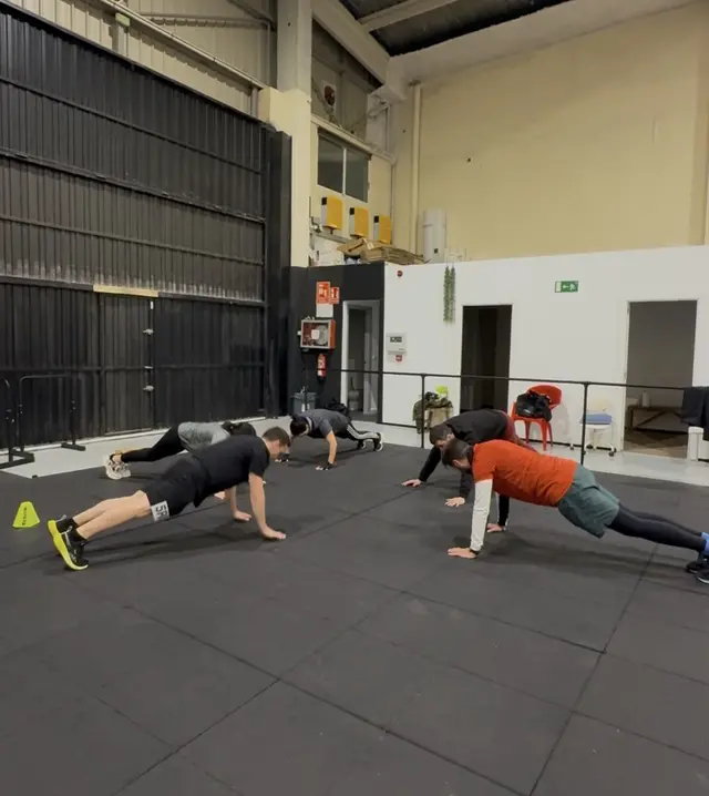 Grupo realizando un ejercicio de entrenamiento funcional en la zona de suelo.